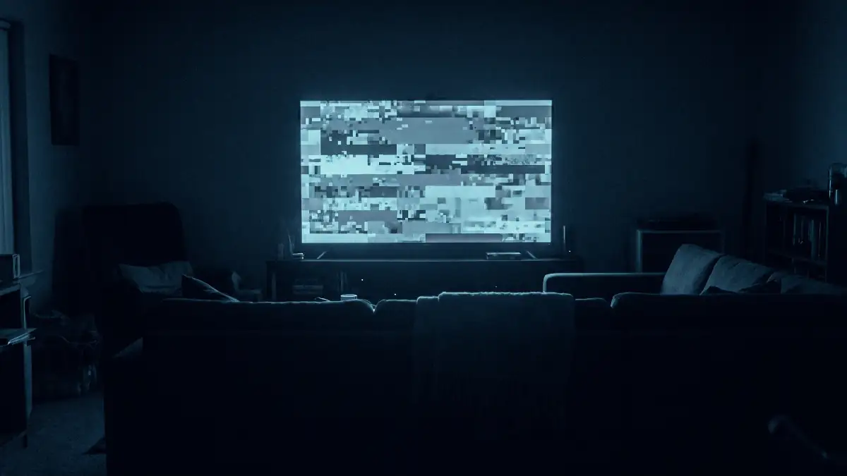 Téléviseur affichant une image figée et pixelisée dans un salon sombre