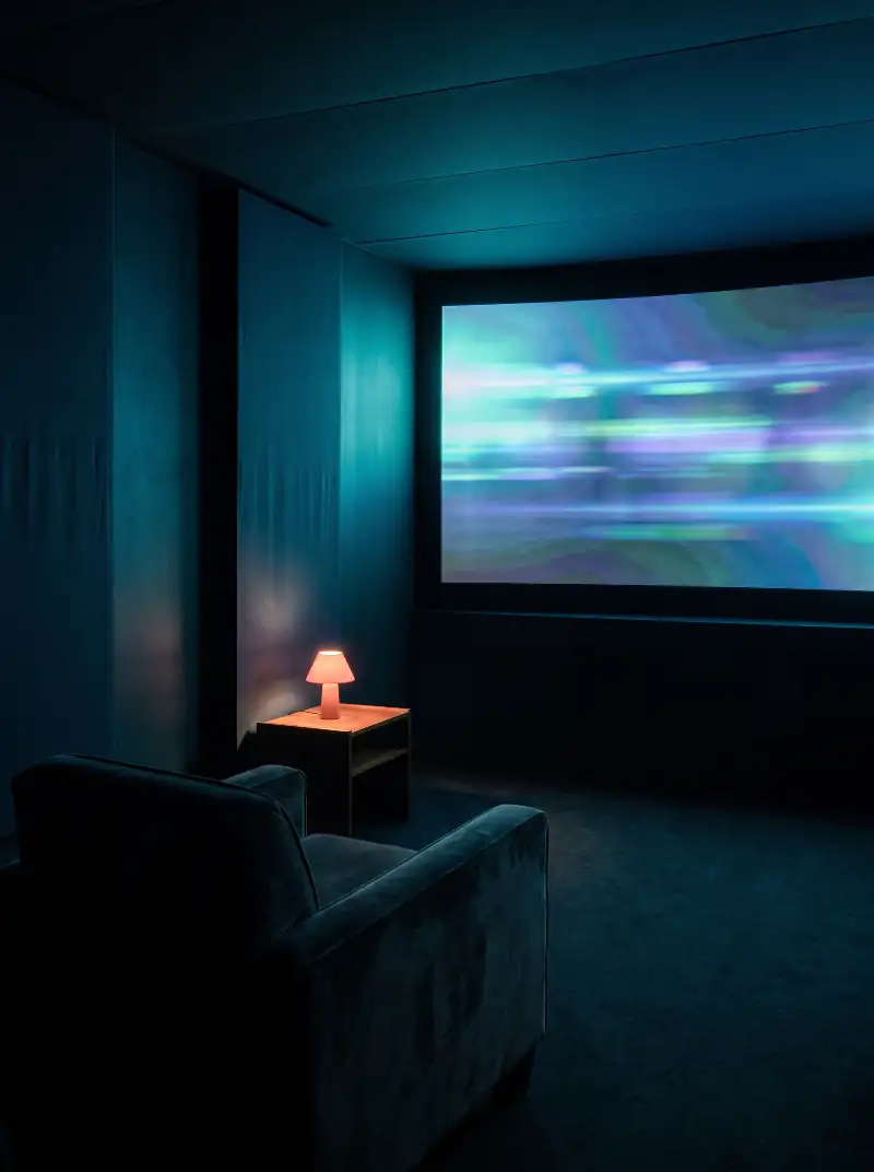 Coin home cinéma sombre, écran large diffusant un film